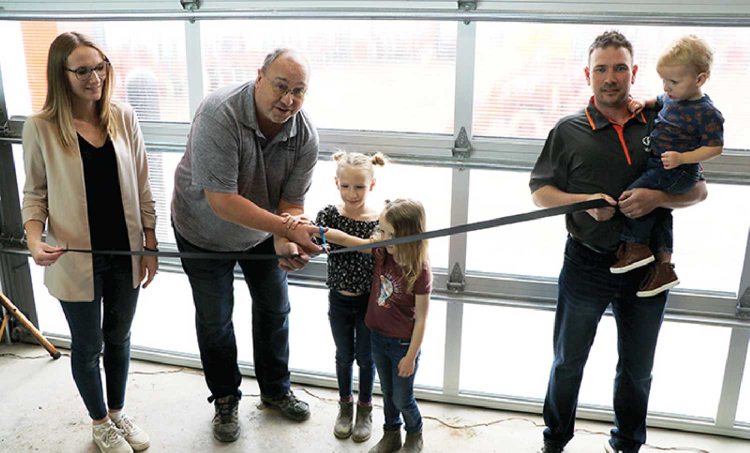 Redvers Mayor Brad Bulbuck officially cut to the ribbon at the grand opening of the new Redvers Ag Kubota dealership on Thursday, April 18. From left are Jenna Dangstorp, Mayor Brad Bulbuck, Talaya Dangstorp, Adele Dangstorp, and Perry Dangstorp holding Kepler Dangstorp.